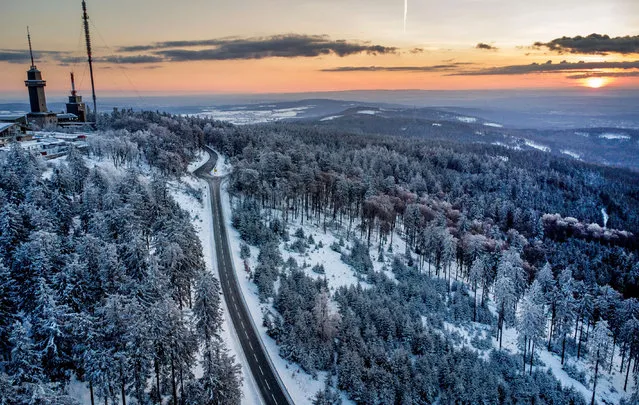 A road leads up to the top of the Feldberg mountain near Frankfurt, Germany, as the sun rises on Sunday, April 3, 2022. (Photo by Michael Probst/AP Photo)