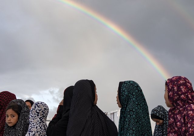 A rainbow appears as displaced Palestinians, who escaped the ongoing conflict between Israel and Hamas, prepare to perform Eid al-Fitr prayers next to their families tents set up near the Egyptian border, at the Rafah camp in the southern Gaza Strip, 10 April 2024. Muslims worldwide celebrate Eid al-Fitr, a two or three-day festival at the end of the Muslim holy fasting month of Ramadan.It is one of the two major holidays in Islam. During Eid al-Fitr, Most People travel to visit each other in town or outside of it and children receive new clothes and money to spend for the occasion.More than 33,100 Palestinians and over 1,450 Israelis have been killed, according to the Palestinian Health Ministry and the Israel Defense Forces (IDF), since Hamas militants launched an attack against Israel from the Gaza Strip on 07 October 2023, and the Israeli operations in Gaza and the West Bank which followed it. (Photo by Haitham Imad/EPA/EFE/Rex Features/Shutterstock)