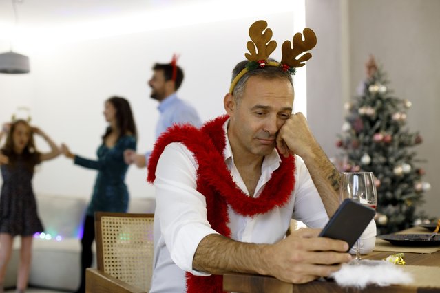 A sad man is waiting for a message on the phone for the New Year. (Photo by Sneksy/Getty ImagesGetty Images)