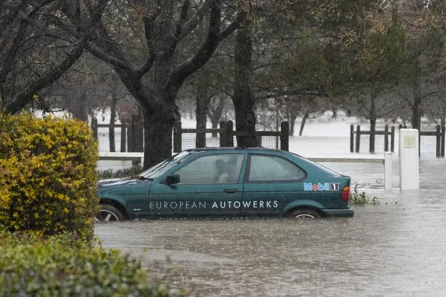 A car lies semi submerged in flood waters at Camden on the outskirts of Sydney, Australia, Monday, July 4, 2022. More than 30,000 residents of Sydney and its surrounds have been told to evacuate or prepare to abandon their homes on Monday as Australia’s largest city braces for what could be its worst flooding in 18 months. (Photo by Mark Baker/AP Photo)