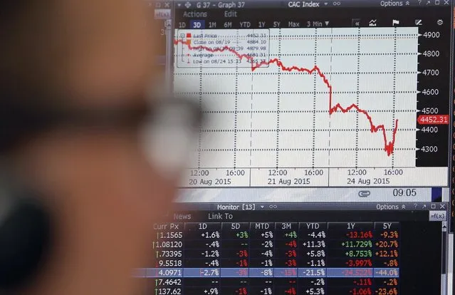 A sales manager looks at a screen which shows the decline in value of French CAC 40 stocks at Allianz Global Investors in Paris, France, August 24, 2015. European stocks slumped on Monday following a rout in Chinese markets, wiping hundreds of billions of euros off leading shares and sending one benchmark index to a seven-month low. (Photo by Regis Duvignau/Reuters)