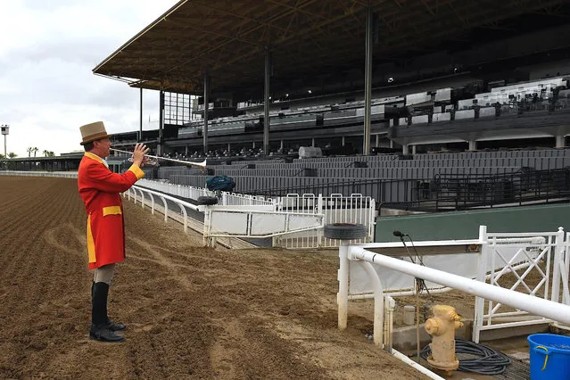 Bugler Jay Cohen plays “First Call” as he calls the riders to post for the first race at Santa Anita Park to empty stands Saturday, March 14, 2020, in Arcadia, Calif. (Photo by Mark J. Terrill/AP Photo)
