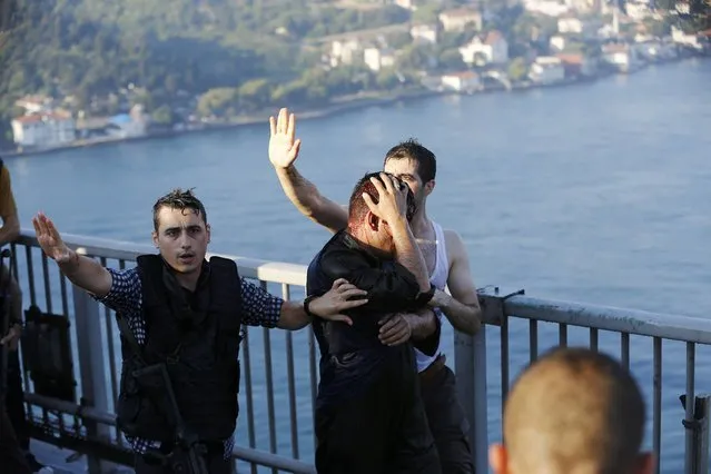 Policemen protect a soldier from the mob after troops involved in the coup surrendered on the Bosphorus Bridge in Istanbul, Turkey July 16, 2016. (Photo by Murad Sezer/Reuters)