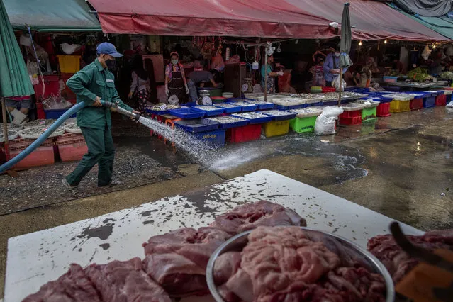A sanitation worker uses a high-pressure water source to wash a market in Bangkok, Thailand, Wednesday, March 25, 2020. Thailand’s government announced Tuesday it will declare an emergency later in the week allowing them to take stricter measures to control the coronavirus outbreak that has infected hundreds of people in the Southeast Asian country. (Photo by Gemunu Amarasinghe/AP Photo)