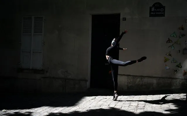 Irish dancer from the Moulin Rouge, Isabelle, practices in the street next to her home in Paris on April 14, 2020, on the 29th day of a strict lockdown aimed at curbing the spread of the COVID-19 pandemic, caused by the novel coronavirus. (Photo by Franck Fife/AFP Photo)