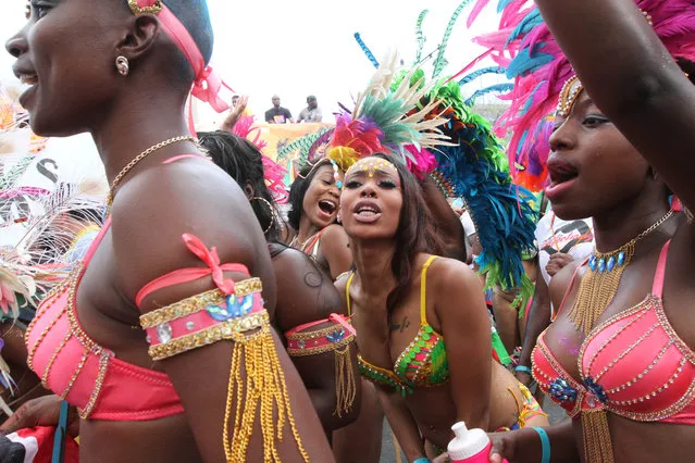 Costumed participants make their way along Eastern Parkway in the Brooklyn borough of New York as they take part in the West Indian Day Parade, Monday, September 1, 2014. (Photo by Tina Fineberg/AP Photo)