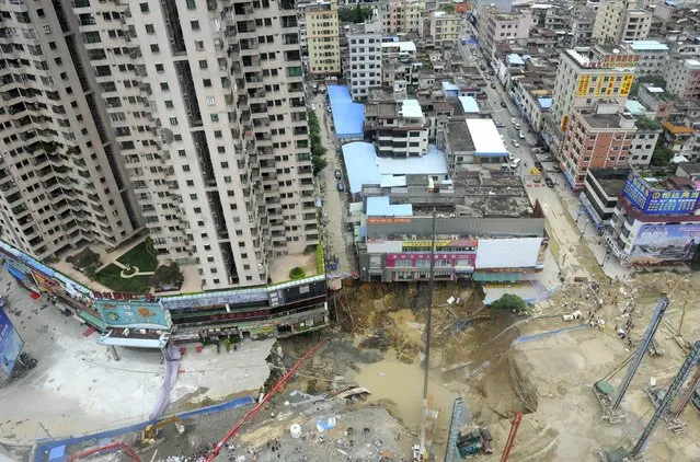 A sinkhole is seen at a construction site near residential and commercial buildings, in Dongguan, Guangdong province, China, August 13, 2015. Roads were blocked and over 200 residents in nearby buildings were evacuated after a second sinkhole occurred at the construction site in two days. One worker was killed as the 300-square-metre area collapsed, local media reported. (Photo by Reuters/Stringer)