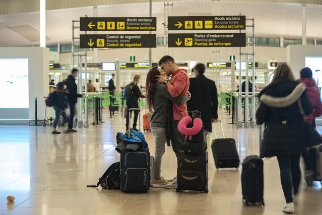A couple kiss inside a terminal of the Barcelona Airport, Wednesday, December 1, 2021. Health authorities in the Spanish capital have confirmed a second case of the omicron coronavirus variant in a 61-year-old woman who had returned from a trip to South Africa on Monday. Meanwhile lines have returned for those seeking vaccine shots in Portugal and Spain as they step up efforts to close the gap of the few residents still unvaccinated. (Photo by Joan Mateu Parra/AP Photo)