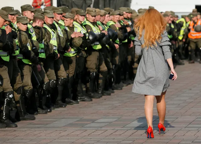 A woman walks past servicemen of the National Guard in front of Ukrainian Parliament during a opposition rally in Kiev, Ukraine October 19, 2017. (Photo by Gleb Garanich/Reuters)