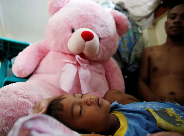 A boy sleeps beside a stuffed toy at an evacuation centre for flood victims in San Mateo, Rizal, Philippines, August 14, 2016. (Photo by Erik De Castro/Reuters)