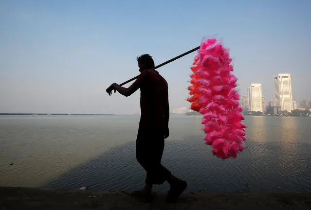 A man selling coloured cotton candy walks on the shores of the Arabian Sea in Mumbai, India, November 8, 2017. (Photo by Shailesh Andrade/Reuters)