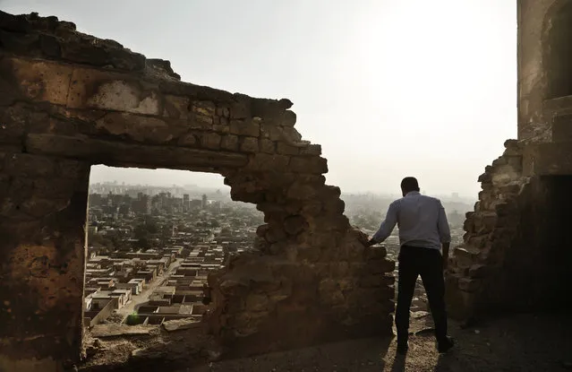 A man looks at the general view of a cemetery from the Shahin Al-Khalwati Mosque in Cairo, Egypt, Wednesday, August 24, 2016. Muslim Sufi Saint Shahin Al-Khalwati built the mosque in the 16th century on top of a hill where he would go into spiritual seclusion. Today the neglected mosque sits on the top of a hill of a cemetery. Al-Khalwati's grandchildren demand the government restore the mosque because it is a heritage site according to civilians who live in the cemetery area. (Photo by Nariman El-Mofty/AP Photo)