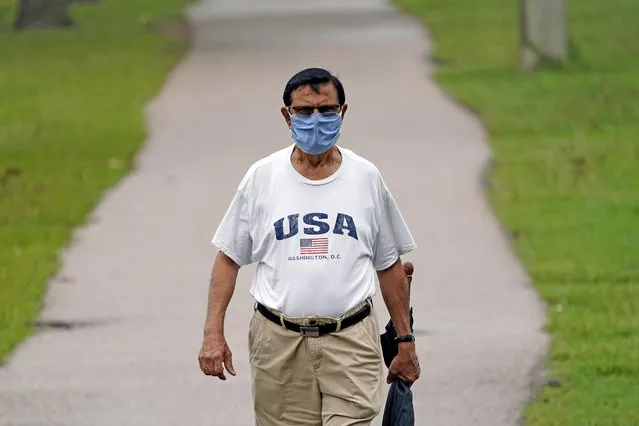 Shiraz Merchant wears a mask as he walks in a park Friday, June 26, 2020, in Houston. The number of COVID-19 cases continues to rise across the state. Texas Gov. Greg Abbott has said that the state is facing a “massive outbreak” in the coronavirus pandemic and that some new local restrictions may be needed to protect hospital space for new patients. (Photo by David J. Phillip/AP Photo)
