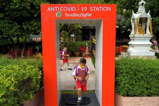 A kindergarten student from the Wichuthit school wearing a face mask cleans his shoe at an anti-COVID-19 station before entering his school during a rehearsal social distancing and measures to prevent the spread of the coronavirus disease (COVID-19) ahead of nationwide school reopening in Bangkok, Thailand, June 23, 2020. (Photo by Athit Perawongmetha/Reuters)