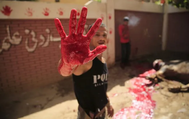 A butcher shows his bloodied handfrom a just-slaughtered calf on the first day of Eid al-Adha festival in Toukh, El-Kalubia governorate, northeast of Cairo, Egypt, September 24, 2015. (Photo by Amr Abdallah Dalsh/Reuters)