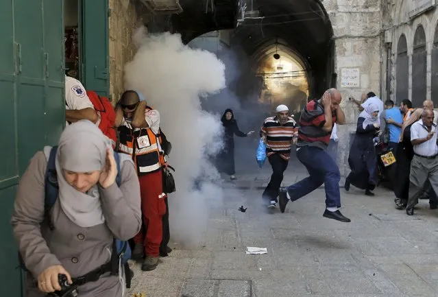 Palestinian protesters run away as Israeli police throw a stun grenade in Jerusalem's Old City September 28, 2015. (Photo by Ammar Awad/Reuters)