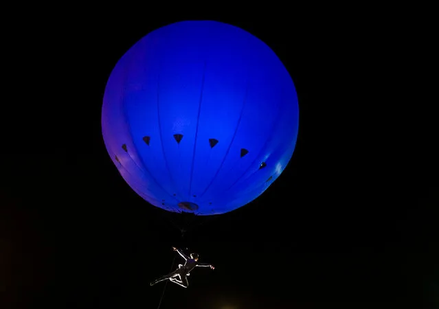 An acrobat is suspended below the Heliosphere, a giant helium balloon, while performing at the city’s Freedom festival in Hull, UK on September 4, 2016. (Photo by Danny Lawson/PA Wire)