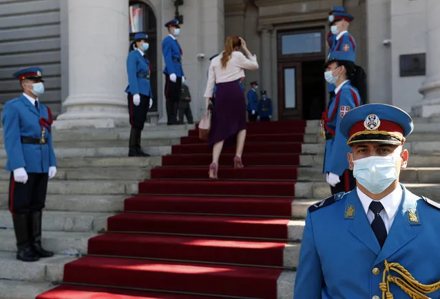 Serbia's army guard of honor wearing face masks to prevent the spread of coronavirus, stand in front of the parliament building before the inaugural parliament session in Belgrade, Serbia, Monday, August 3, 2020. The Serbian parliament reconvened Monday amid protests by opposition and far-right supporters who claim the parliamentary election that was overwhelmingly won by the ruling populists was rigged. (Photo by Darko Vojinovic/AP Photo)