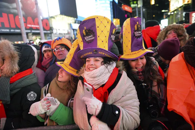 People gather in Times Square during New Year's Eve celebrations, Sunday, December 31, 2017, in New York. New Yorkers, celebrity entertainers and tourists from around the world are packing into a frigid Times Square Sunday to mark the start of 2018 with a glittering crystal ball drop, a burst of more than a ton of confetti and midnight fireworks. (Photo by Go Nakamura/AP Photo)