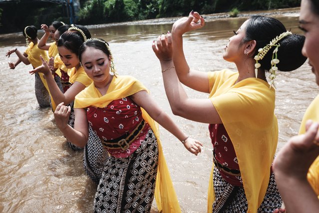 Dancers release fish in the Progo River as part of a traditional Buddhist life-release ritual held on the eve of Waisak, or Vesak Day, in Magelang, Central Java, on May 11, 2025. Vesak is the most sacred day for Buddhists, commemorating the birth, enlightenment and death of Siddhartha Gautama, the Buddha, all traditionally believed to have occurred on the full moon day of the Vesakha month in the ancient Indian lunar calendar. (Photo by Yasuyoshi Chiba/AFP Photo)