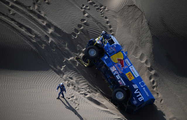 Kamaz Russian driver Eduard Nikolaev, co- drivers Evgeny Yakovlev and mechanic Vladimir Rybakov are stuck in the sand after their truck tipped over during the 2018 Dakar Rally Stage 5 between San Juan De Marcona and Arequipa in Peru, on January 10, 2018. Sebastien Loeb was forced to pull out of the Dakar Rally after a back injury suffered by his co- driver in a disastrous fifth stage won by defending champion Stephane Peterhansel. (Photo by Franck Fife/Reuters)