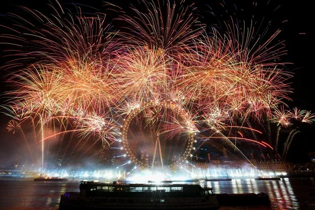 Fireworks explode over the London Eye ferris wheel as Britons across the country welcome the New Year, in London, Britain on January 1, 2023. (Photo by Maja Smiejkowska/Reuters)