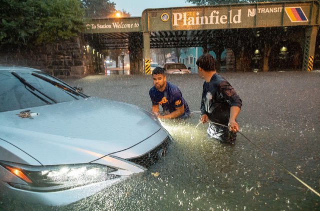 Men try to tow their car out of the rain swell during a flash flood on Watchung Avenue in Plainfield, New Jersey on July 14, 2025. Motorists and residents were left stranded in their cars, the local high school and reports of flooded homes. Earlier in July Plainfield suffered fatalities from a heavy storm that contained hail and heavy winds tearing down power lines and damaging homes in Plainfield along with other Central Jersey towns. (Photo by Brian Branch Price/ZUMA Press Wire via Alamy Live News)