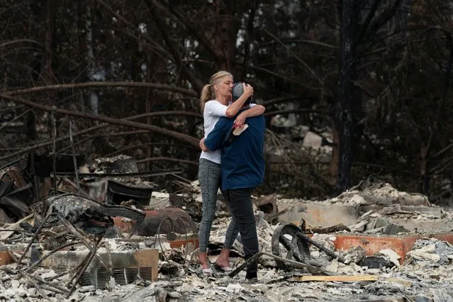 Christina Mitchell embraces her fiance, George Schmoll, amidst the remnants of their apartment after losing items such as her wedding dress and his wedding ring for their December wedding, now postponed, after a wildfire came through the area in Phoenix, Oregon, U.S. September 18, 2020. (Photo by David Ryder/Reuters)