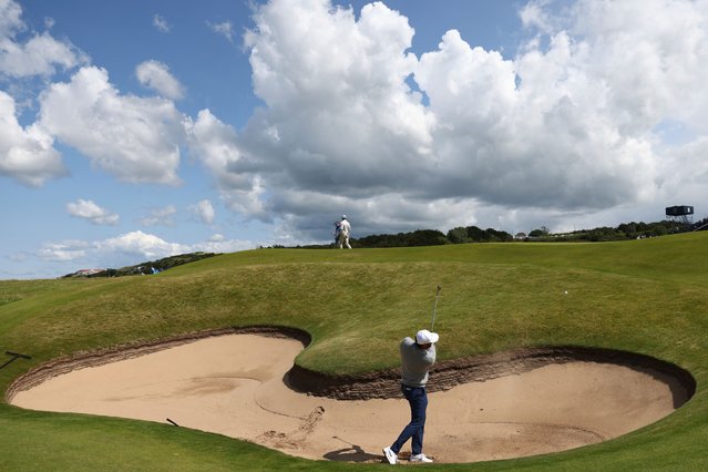 Scottie Scheffler of the United States plays out of a bunker on the 16th hole during a practice round for the 2025 British Open golf championship at the Royal Portrush Golf Club, Northern Ireland, Monday, July 14, 2025. (Photo by Peter Morrison/AP Photo)