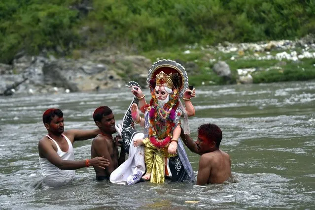 Nepalese Devotees immerse the idol of lord Vishwakarma in the Bagmati river at Kathmandu, Nepal Friday, September 18, 2020. Vishwakarma is the deity of the creative power considered to be the original creator, architect, divine engineer of the universe. (Photo by Narayan Maharjan/NurPhoto via Getty Images)