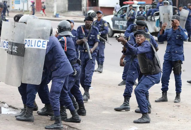 Policemen react after a protester threw a stone from Notre Dame Cathedral compound in Kinshasa, Democratic Republic of Congo, February 25, 2018. (Photo by Goran Tomasevic/Reuters)