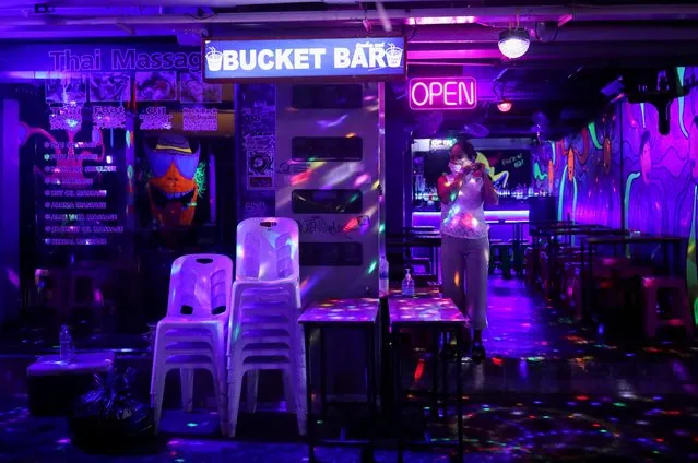 A bar owner wears a face mask as she waits for customers at her empty shop in Khaosan road during the coronavirus disease (COVID-19) outbreak, in Bangkok, Thailand, October 12, 2020. (Photo by Soe Zeya Tun/Reuters)