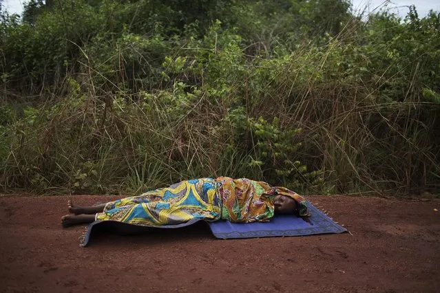 A woman lies on the road dying from a gunshot wound to the head close to the village of Dekoa after the armed peacekeeping convoy from the African Union operation in the country (MISCA) she was travelling in came under attack by anti-Balaka militiamen, as it travelled towards the towns of Kabo and Sido in the north on the border with Chad, in this April 28, 2014 file photo. (Photo by Siegfried Modola/Reuters)