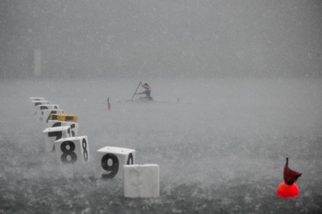 A canoeist competes during a hailstorm at the ICF Canoe Sprint World Championships in Milan, Italy, 21 August 2025. (Photo by Zsolt Czeglédi/EPA)