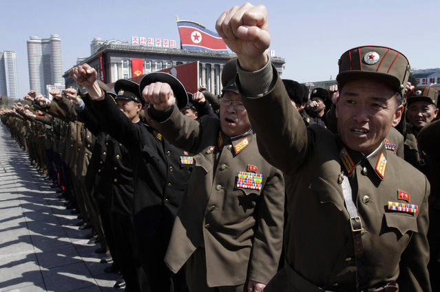 North Korean army officers punch the air as they chant slogans during a rally at Kim Il Sung Square in downtown Pyongyang, North Korea, Friday, March 29, 2013. Tens of thousands of North Koreans turned out for the mass rally at the main square in Pyongyang in support of their leader Kim Jong Un's call to arms. (Photo by Jon Chol Jin/AP Photo)