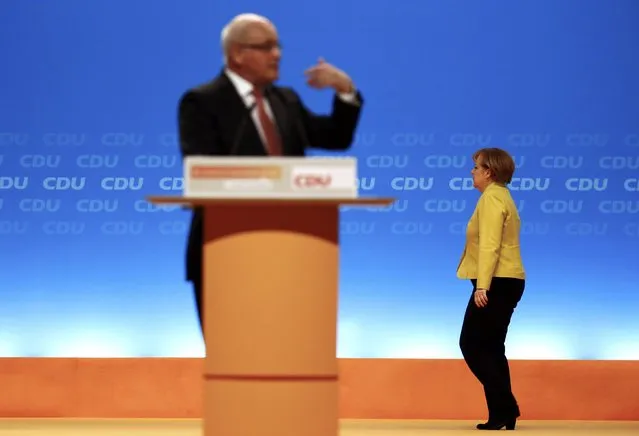 German Chancellor and Christian Democratic Union (CDU) leader Angela Merkel walks on stage during the speech of Volker Kauder, parliamentary faction leader during the last day of the party convention in Cologne December 10, 2014. The CDU party is holding its 27th party convention from December 8-10. (Photo by Kai Pfaffenbach/Reuters)