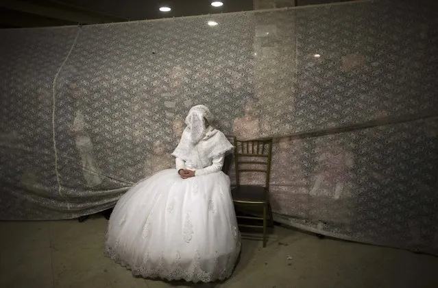 Ultra-orthodox Jewish bride Rivka Hannah Krois watches her groom dance after their traditional wedding ceremony in the Mea Shearim neighbourhood of Jerusalem, in this February 19, 2014 file photo. (Photo by Ronen Zvulun/Reuters)