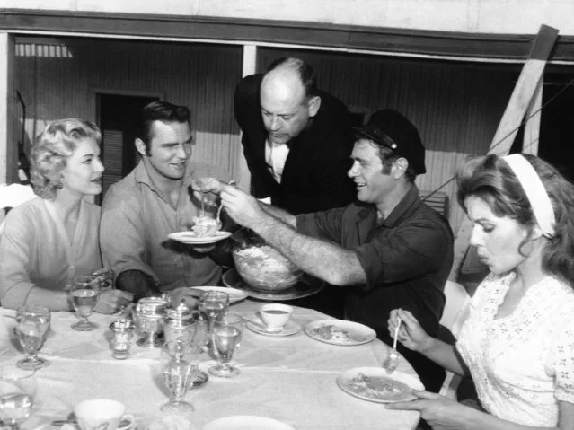 The engagement of actor Burt Reynolds (second from left) to starlet Lori Nelson, left, is celebrated, December 15, 1959 at a luncheon on board the Enterprise, setting for the NBC-TV series “Riverboat”. The host, Darren McGavin, busy serving salad, is the star of the series. Reynolds is the co-star. At right is Pat Crowley, a “Riverboat” guest star. The riverboat Enterprise, one of TV's largest props, sits on a Hollywood studio lot. (Photo by AP Photo)