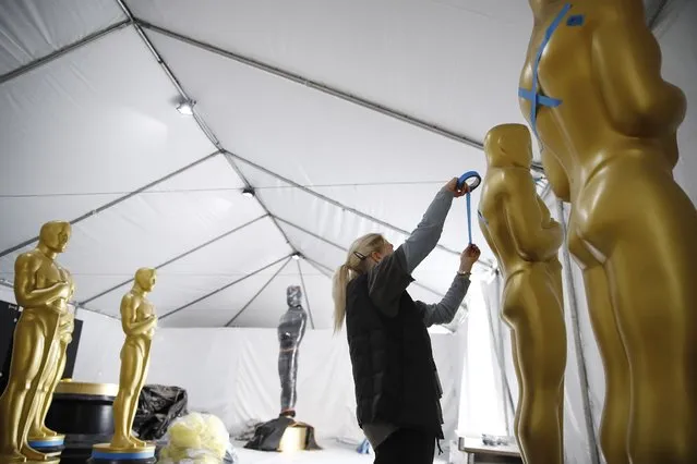 Antje Menikheim puts tape on an Oscar statue as various statues are worked on as preparations for the 95th annual Academy Awards ceremony get underway in Los Angeles, California, USA, 08 March 2023. The 95th Academy Awards ceremony will take place at the Dolby Theatre in Los Angeles on 12 March 2023. (Photo by Caroline Brehman/EPA)