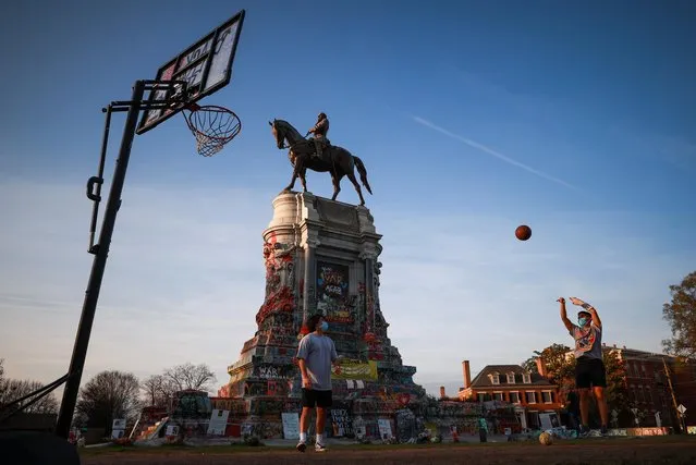 People play basketball on a hoop set up at the base of the monument to Confederate General Robert E. Lee, in Richmond, Virginia, U.S. November 21, 2020. (Photo by Hannah McKay/Reuters)