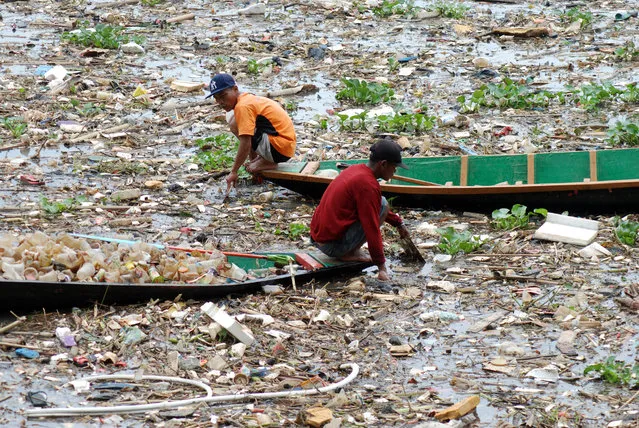 Two scavengers collect plastics in the Citarum river in Bandung, West Java on March 28, 2023. (Photo by Timur Matahari/AFP Photo)