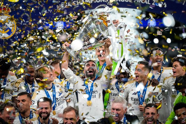 Real Madrid players celebrate with the trophy after winning the Champions League final on Saturday, June 1, 2024. Madrid defeated Borussia Dortmund 2-0 to win its record-extending 15th European Cup. (Photo by Kirsty Wigglesworth/AP Photo)