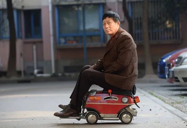 This picture taken on December 24, 2014 shows Xu Zhiyun posing with a mini car he assembled in his community in Shanghai. 60-year-old Xu Zhiyun spent two years making the car which measures only 60cm long, 35cm wide, 40cm high, travels at 20 km per hour and cost 1500 yuan, local media reported. (Photo by AFP Photo)