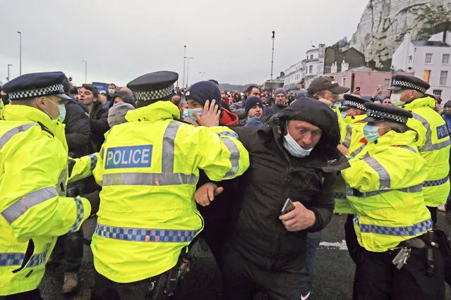 Truck drivers argue with police holding them back at the entrance to the Port of Dover, in Kent, England, Wednesday December 23, 2020. Freight from Britain and passengers with a negative virus test began arriving on French shores Wednesday, after France relaxed a two-day blockade over a new virus variant that had isolated Britain, stranded thousands of drivers and raised fears of shortages. (Photo by Steve Parsons/PA Wire via AP Photo)