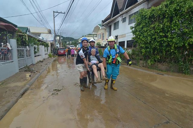 Rescuers evacuate a resident from their flood-hit home following heavy rains brought by Typhoon Kalmaegi in a subdivision of Cebu City in the central Philippines on November 4, 2025. (Photo by Alan Tangcawan/AFP Photo)