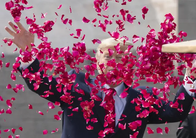 U.S. President Donald Trump offers floral respects at Raj Ghat, the memorial for Mahatma Gandhi, in New Delhi, India, Tuesday, February 25, 2020. (Photo by Alex Brandon/AP Photo)