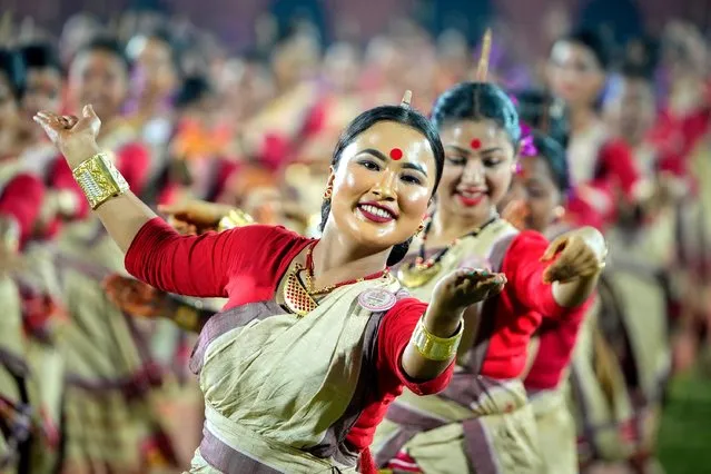 Assamese dancers in traditional attire perform as they attempt Guinness World Record in the largest folk dance performance category in Guwahati, India, Friday, April 14, 2023. Around 11,000 Bihu dancers and musicians performed together to set a new record for Guinness World Record in the largest folk dance performance category today. (Photo by Anupam Nath/AP Photo)