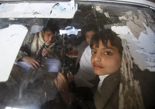 Boys hold rifles as they ride a car to a demonstration against Saudi-led strikes in Yemen's capital Sanaa November 20, 2015. (Photo by Khaled Abdullah/Reuters)