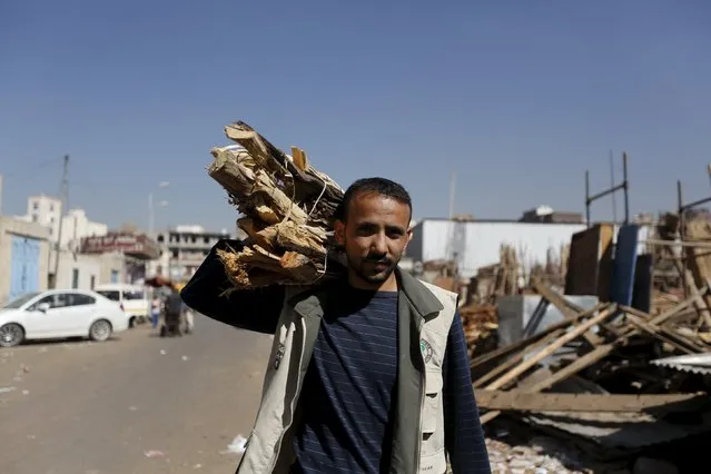 A man carries firewood he bought from a market amid ongoing fuel and cooking gas shortages in Yemen's capital Sanaa, December 2, 2015. (Photo by Khaled Abdullah/Reuters)