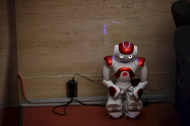 A “Nao” humanoid robot by Aldebaran Robotics sits in a corner while its batteries are being charged during a presentation at a branch of the Bank of Tokyo-Mitsubishi UFJ (MUFG) in Tokyo April 13, 2015. (Photo by Thomas Peter/Reuters)